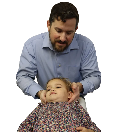 Dr. Larry Masula adjusting a pediatric patient's neck